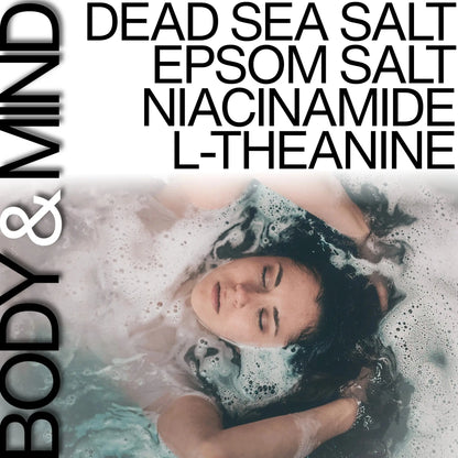 Person relaxing in a bath with text listing Dead Sea Salt, Epsom Salt, Niacinamide, and L-Theanine.