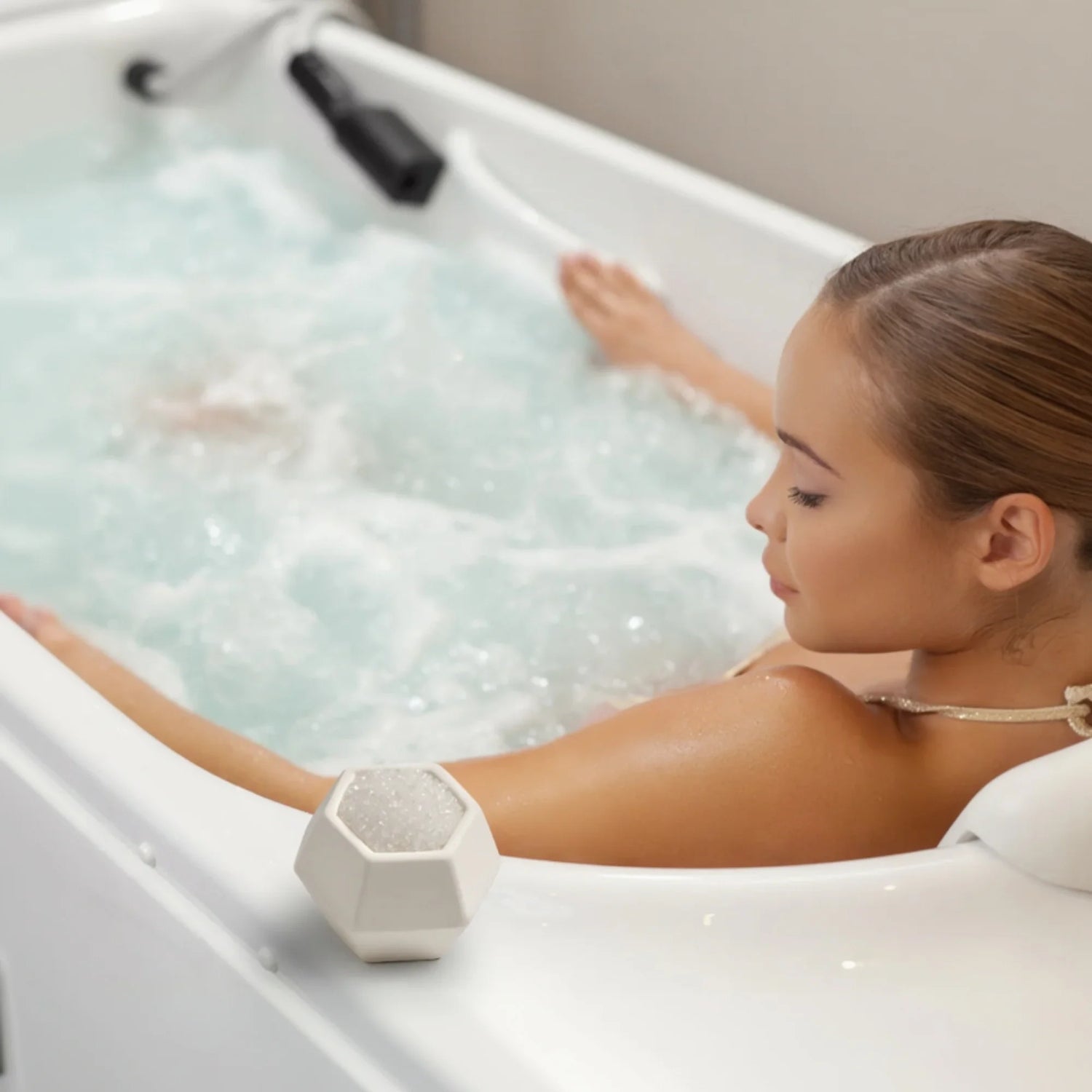 Woman relaxing in bathtub with geobath bath bomb near her