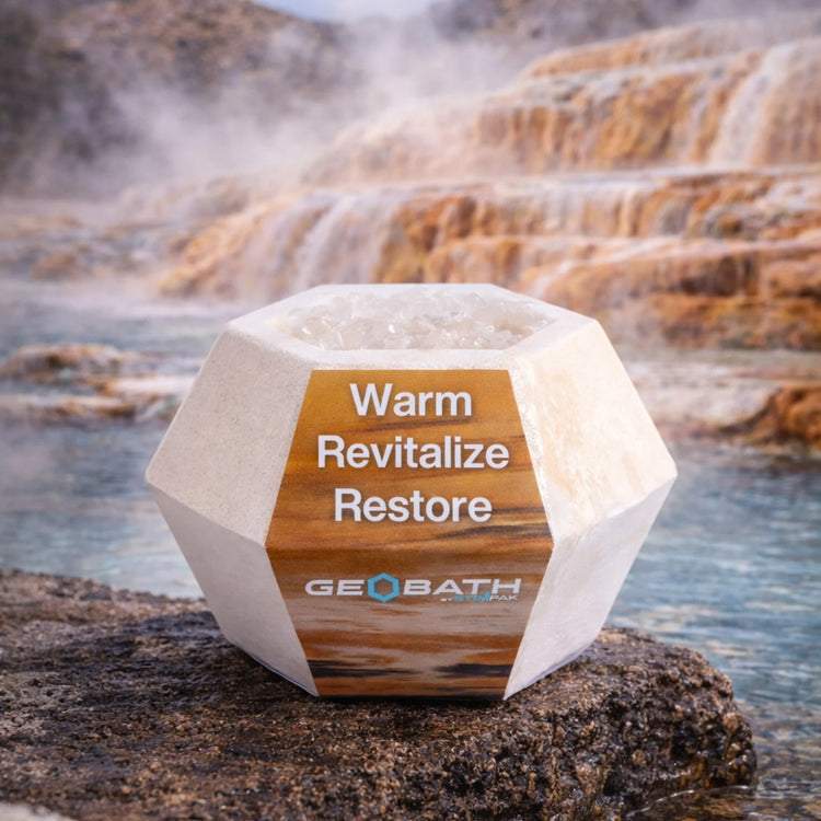 Geobath Geode Bath Bomb with 'Warm Revitalize Restore' text against a natural hot spring background