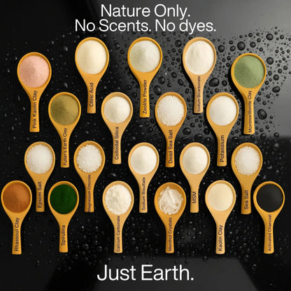 Wooden spoons with various natural powders on a black background with water droplets, featuring 'Just Earth' branding.