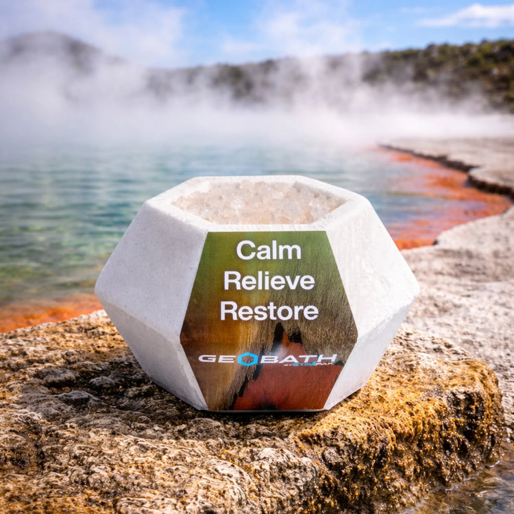 Geobath Geode Bath Bomb with 'Calm Relieve Restore' text by a geothermal pool