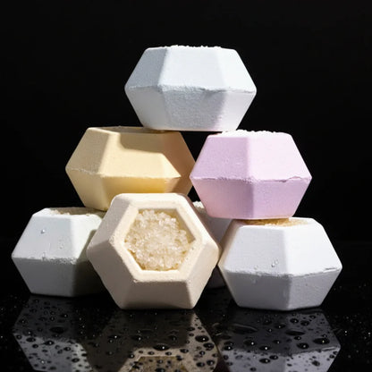 Hexagonal bath bombs in pastel colors on a black background