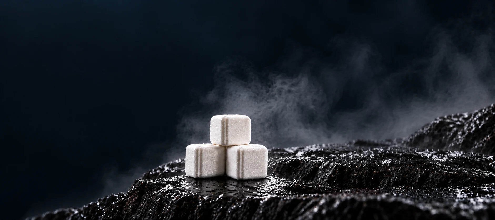STiiMPAK Energy, Synergy and Recovery Triple Pak packaging beside square shower steamer tablets on wet stone.